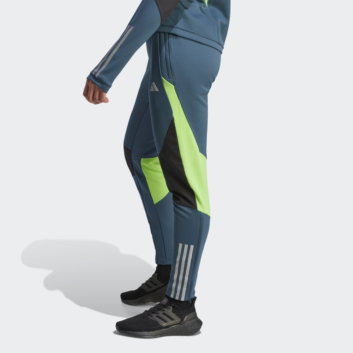 Adidas Tiro 23 Competition Winterized Tracksuit Bottoms. a woman in a light blue sweater and beige pants. 