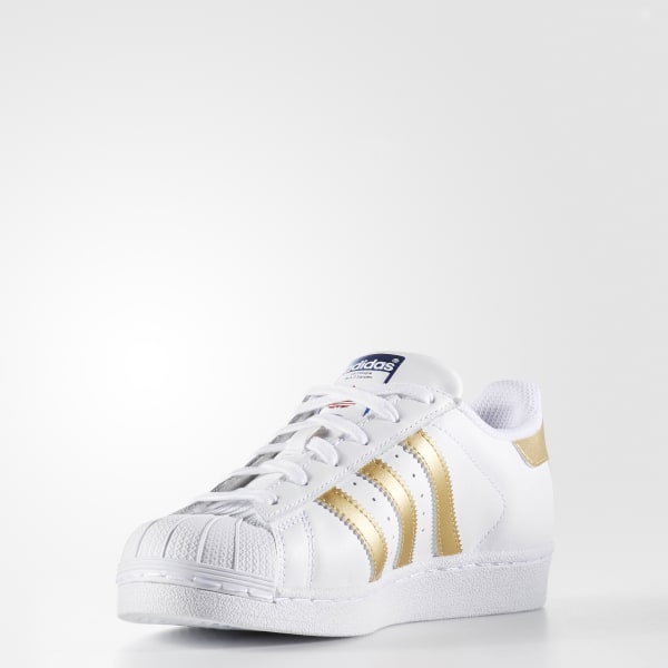 white adidas with gold stripes