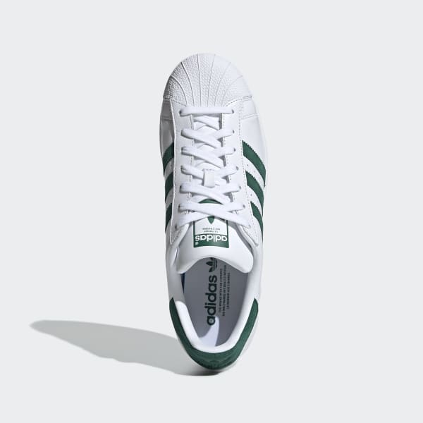white adidas trainers with green stripes